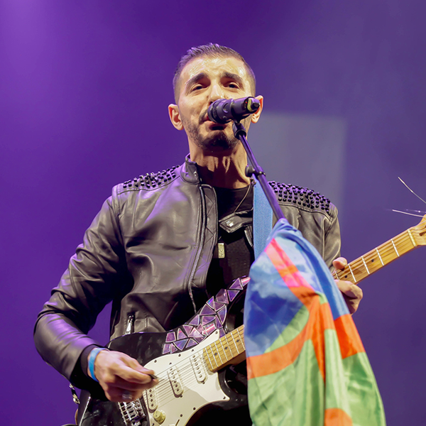 Músico toca guitarra eléctrica con bandera amazhig