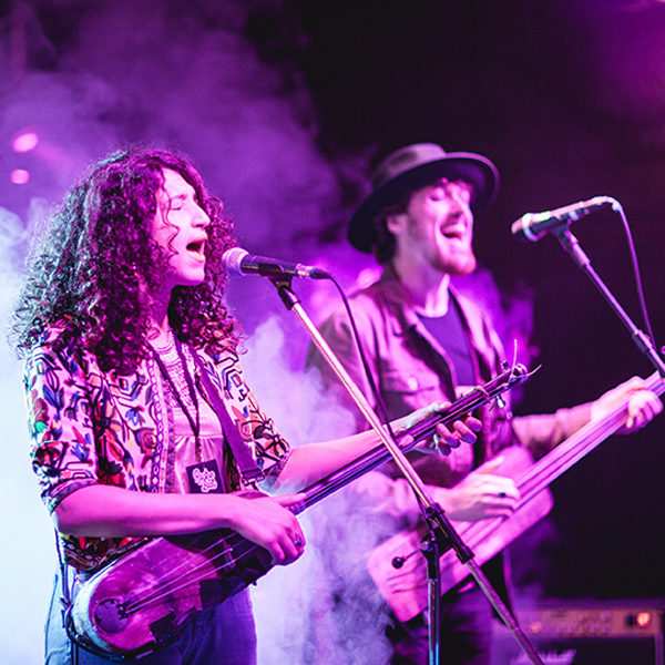Grupo musical. Pareja cantantes actúan en escenario.