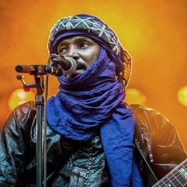 Artista con turbante azul tuareg tocando guitarra
